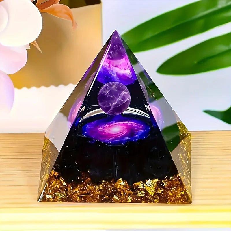 Pyramid-shaped decorative item with purple and gold elements on a wooden surface.
