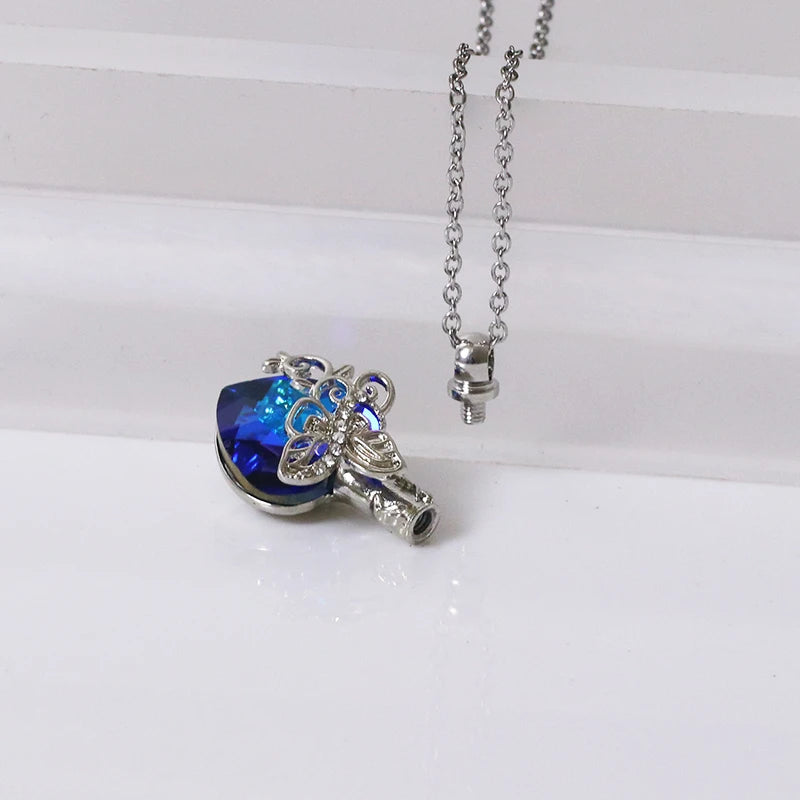 Silver necklace with a blue heart-shaped pendant on a white background