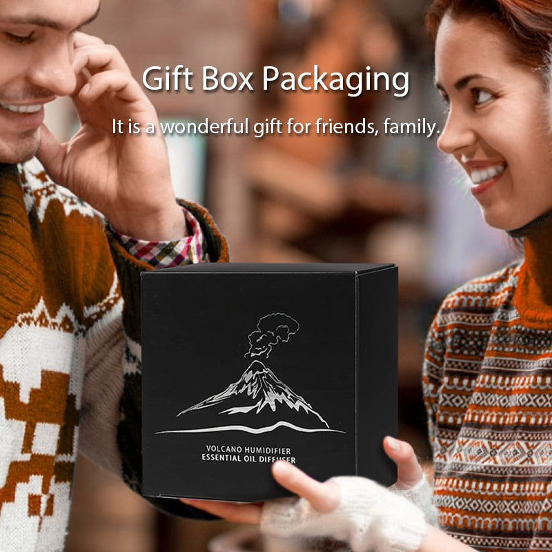 Two people holding a black gift box with a volcano humidifier design, text 'Gift Box Packaging' and 'It is a wonderful gift for friends, family.'.