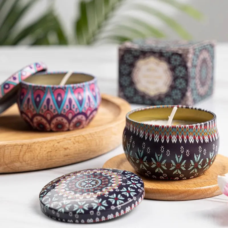 Decorative candles with patterned lids on a wooden surface