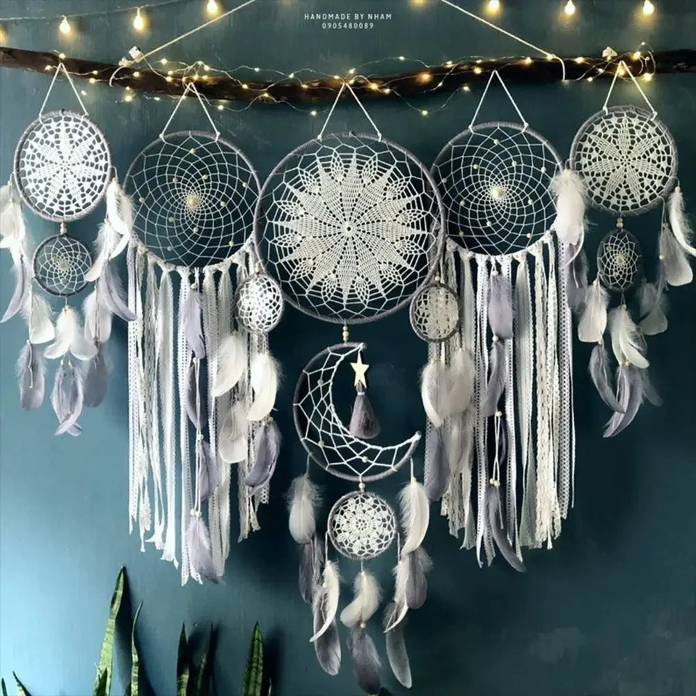 Decorative dreamcatchers with feathers hanging against a dark blue wall.