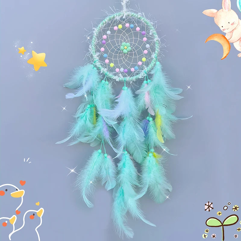 Green dreamcatcher with feathers on a light blue background