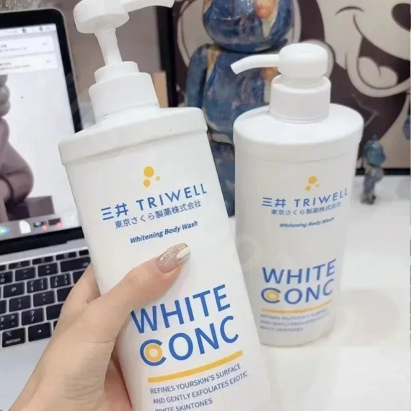 Two bottles of Triwell White Conc Whitening Body Wash held by a hand with a blurred background.