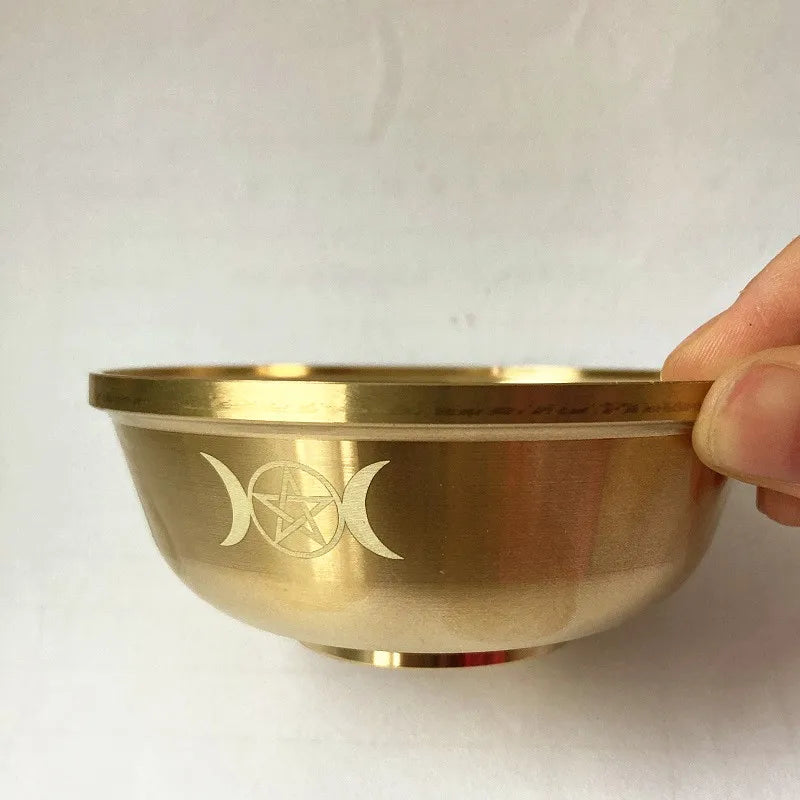 Gold bowl with a symbol held by a hand on a white background