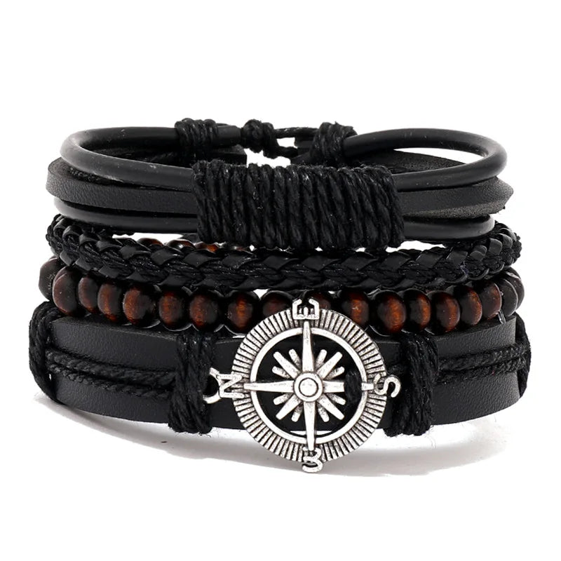 Stack of black leather and wood beaded bracelets with a silver compass charm on a white background