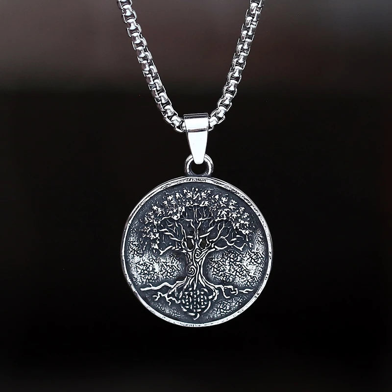 Silver tree pendant necklace on a dark background