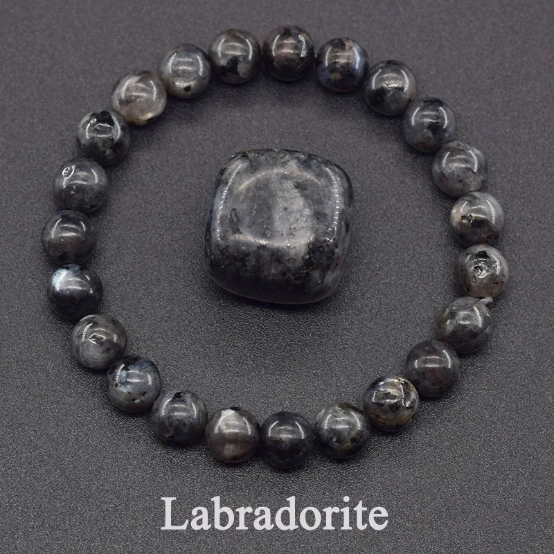 Labradorite stone with a bracelet made of similar stones on a dark background