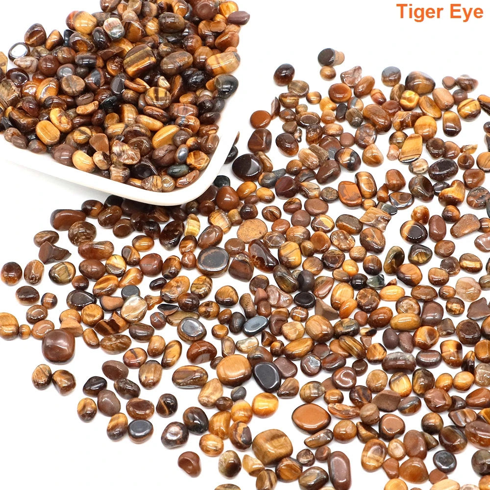 Tumbled tiger eye stones with a white scoop on a white background