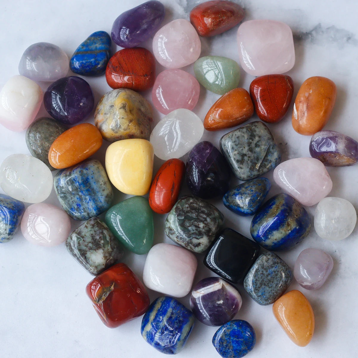 Assorted colorful gemstones on a marble surface