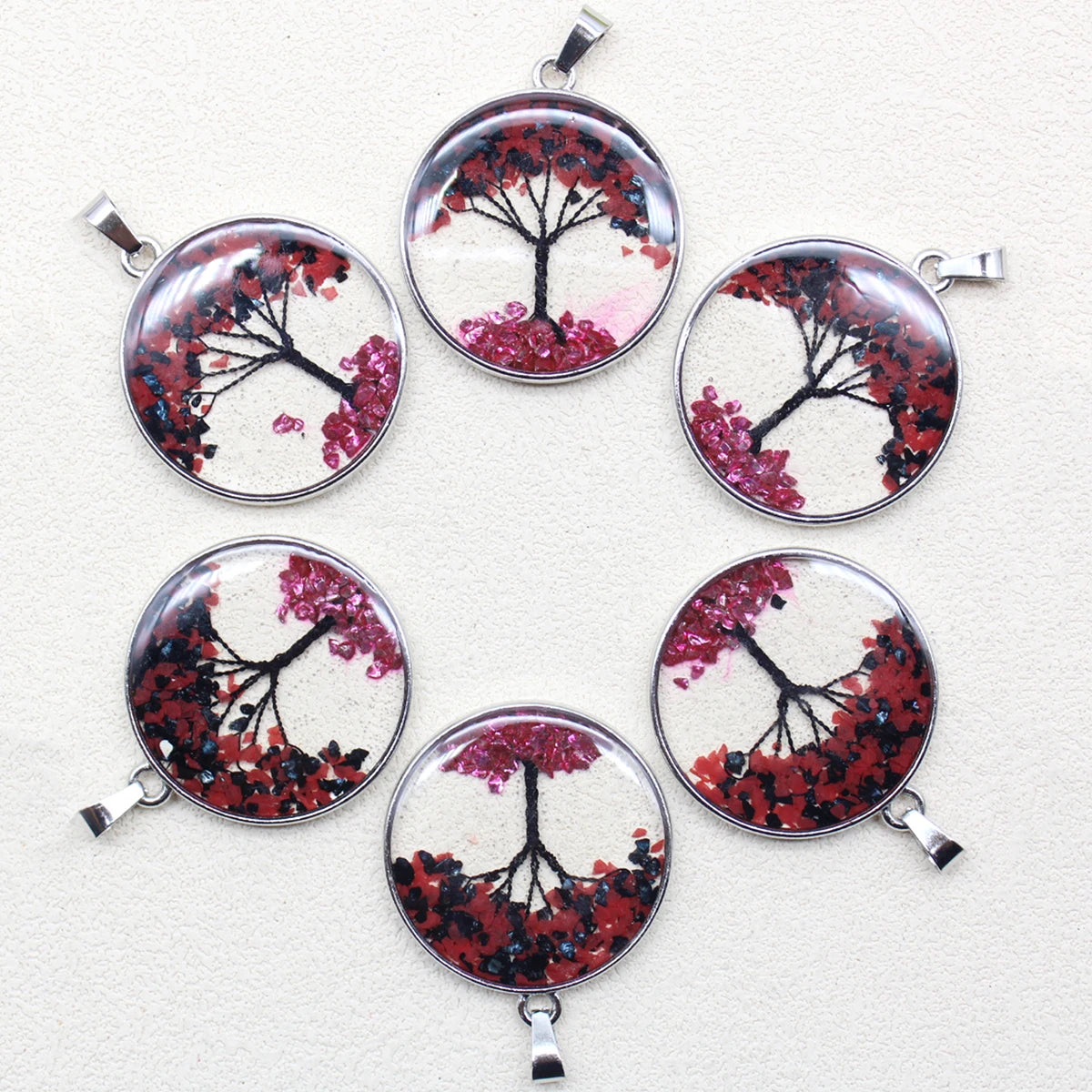 Set of six circular pendants with tree designs on a white background