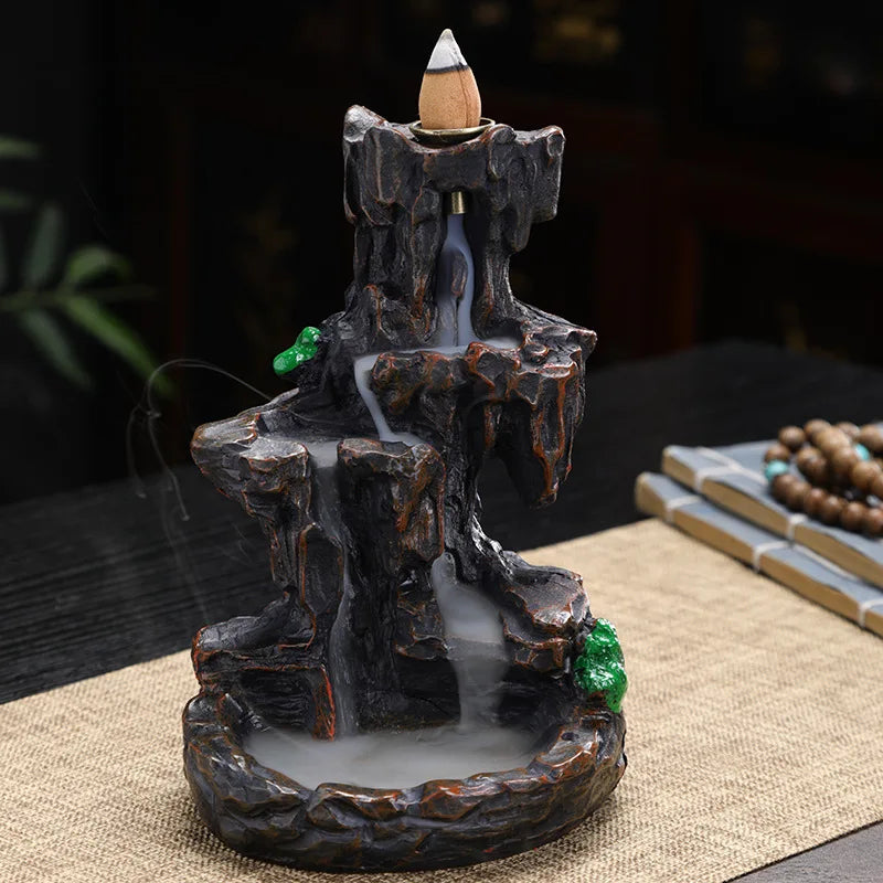 Backflow incense burner with a mountain design on a table.