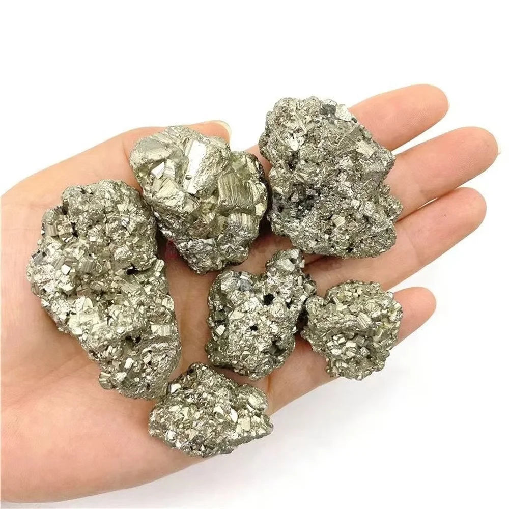 Hand holding pyrite crystals against a white background