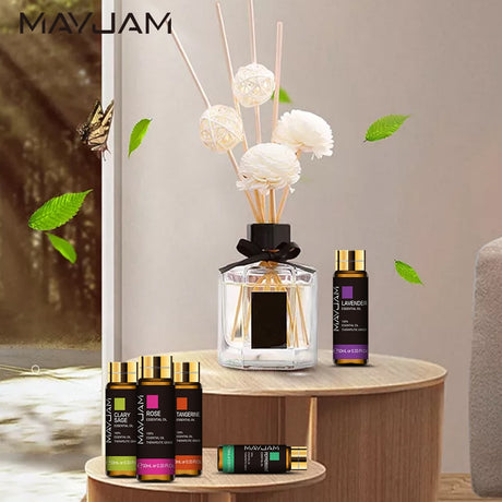 MayJam diffuser and essential oil bottles on a wooden table with decorative elements.