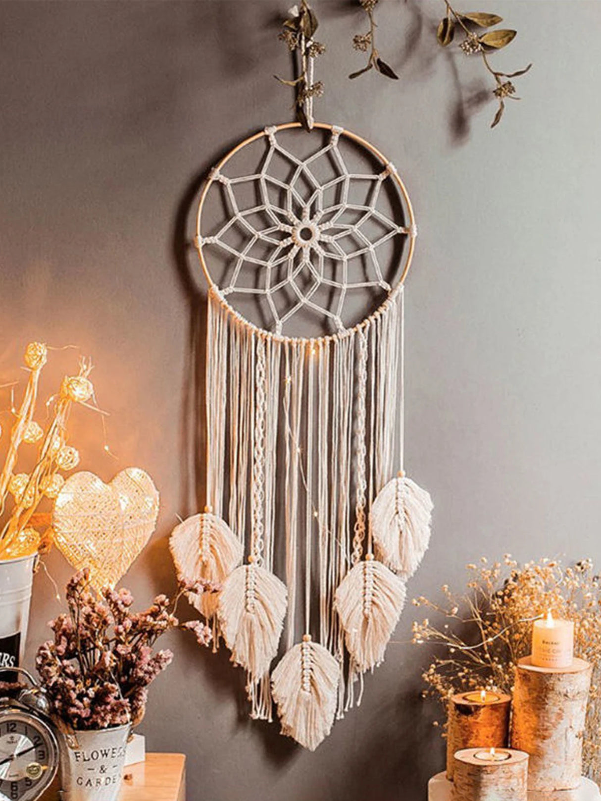 Dreamcatcher hanging on a wall with decorative elements like candles and plants.