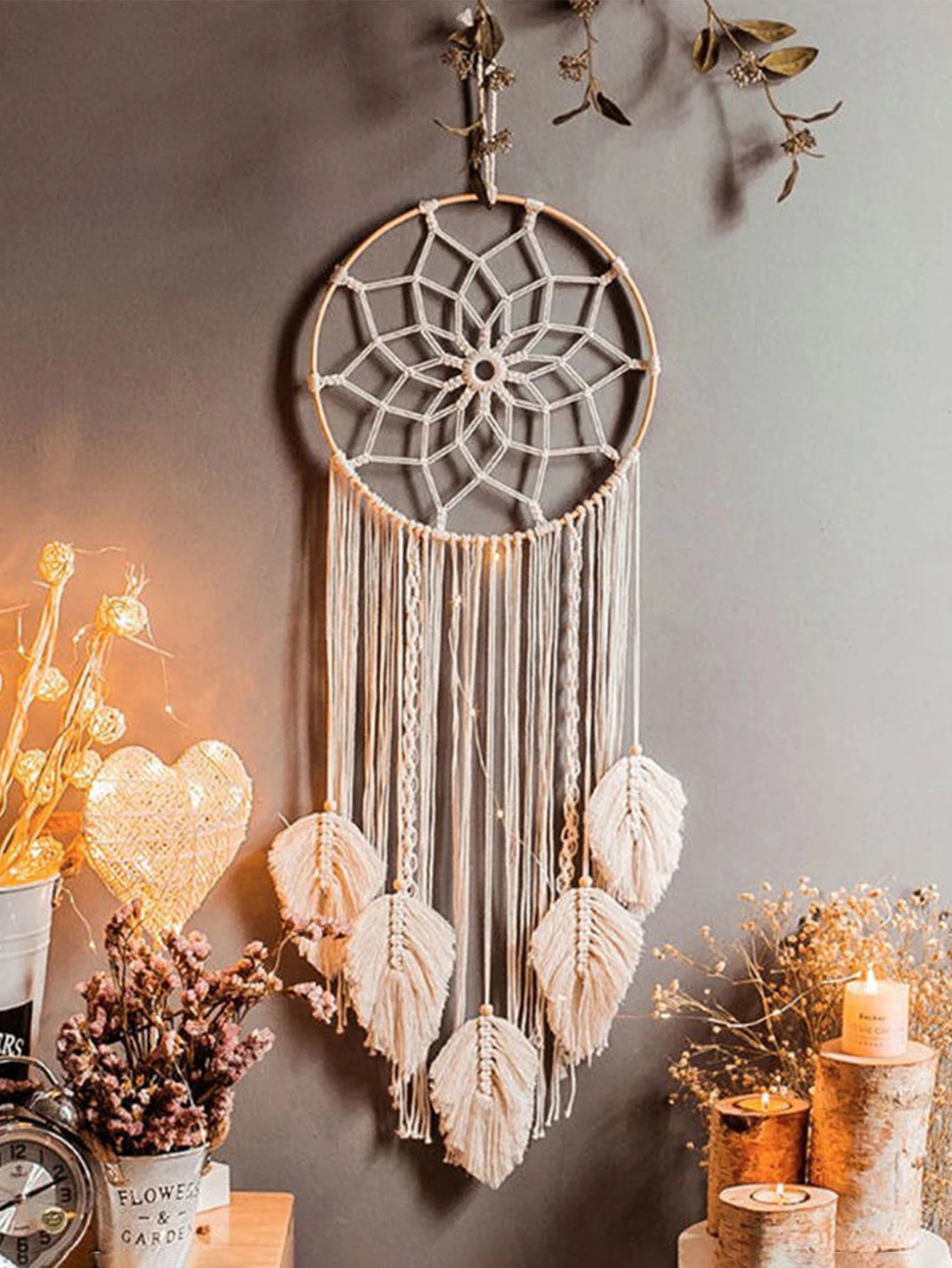 Dreamcatcher hanging on a wall with decorative elements like candles and plants.