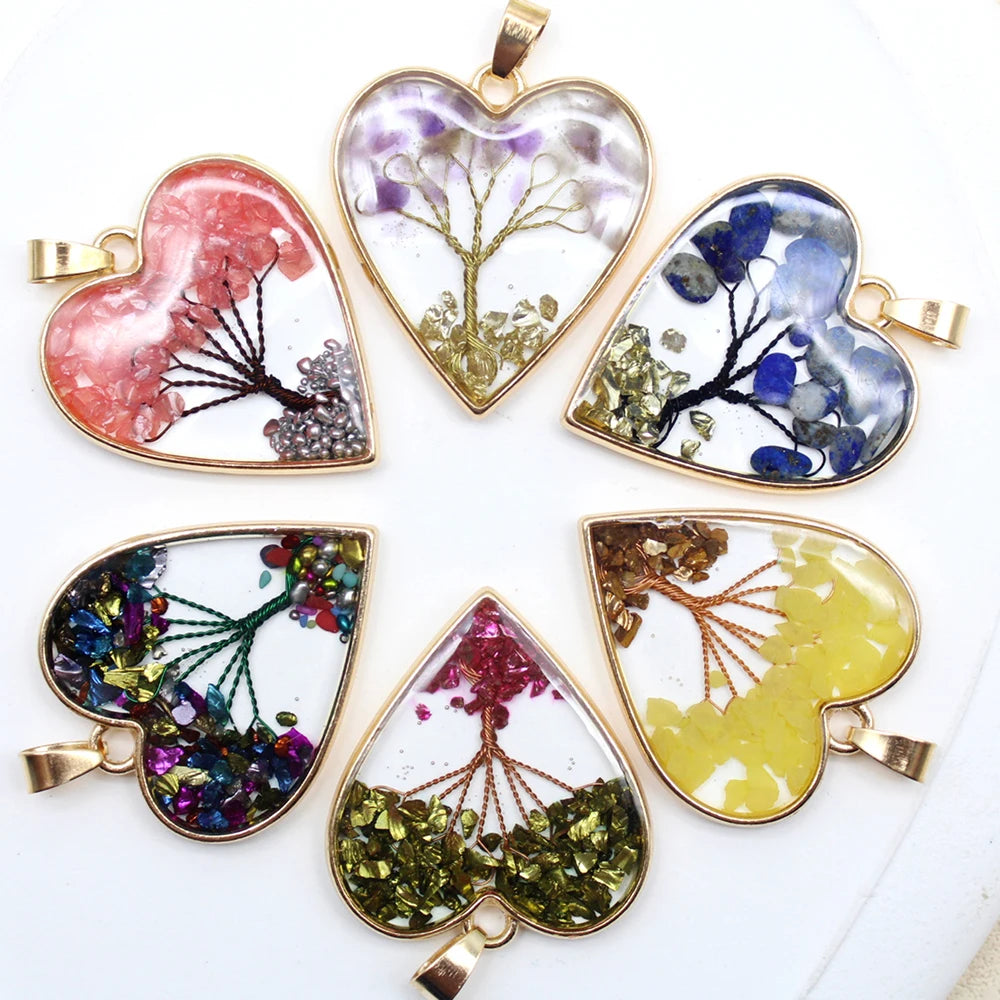 Heart-shaped pendants with tree designs and colorful elements on a white background
