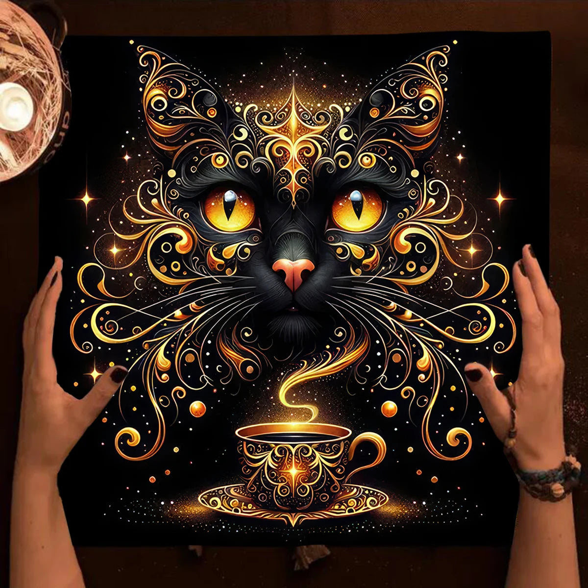 Decorative mat with a stylized cat face and cup design, held by hands.