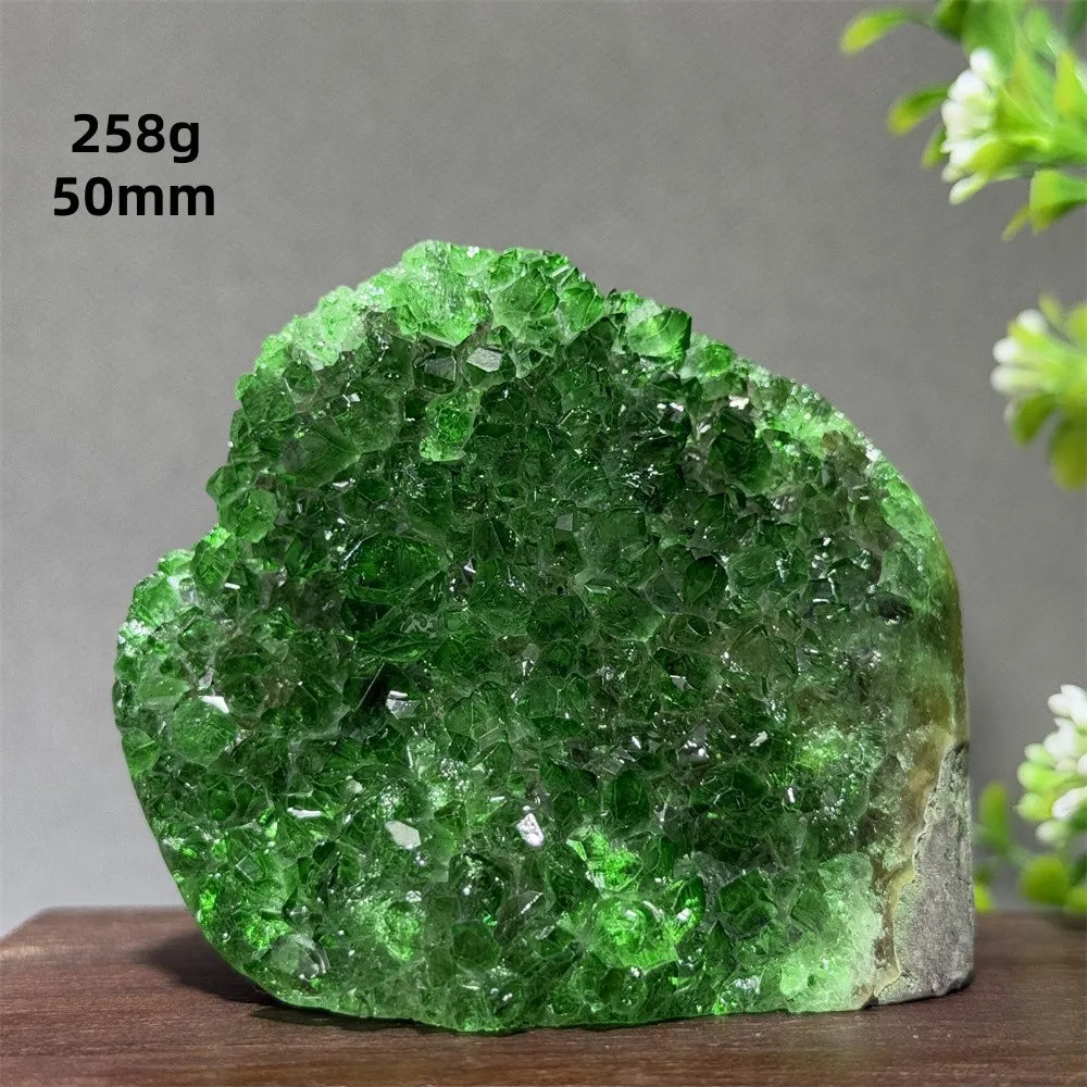 Green crystal rock on a wooden surface with a gray background
