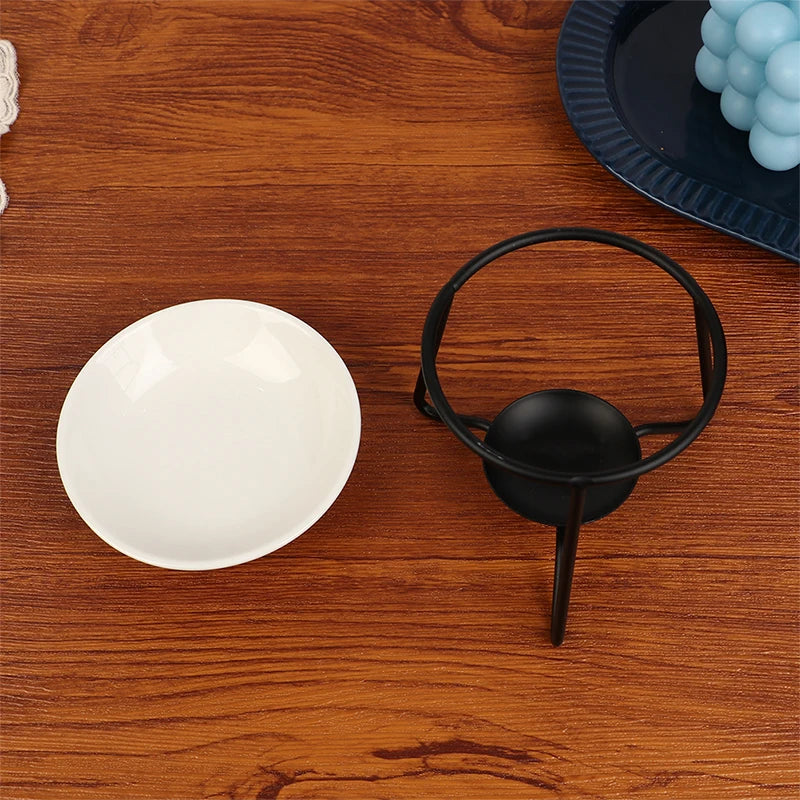 White ceramic bowl and black metal cup on a wooden surface