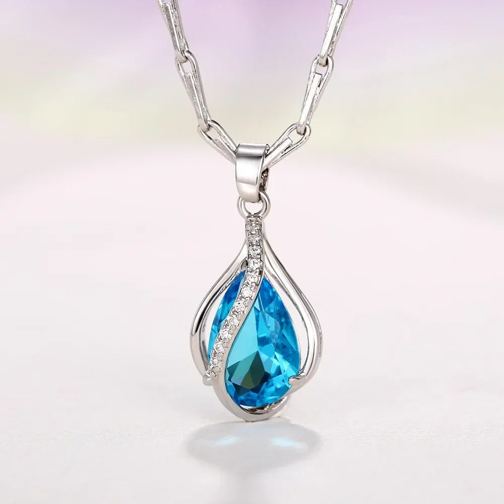 Silver necklace with a blue teardrop pendant on a gradient background