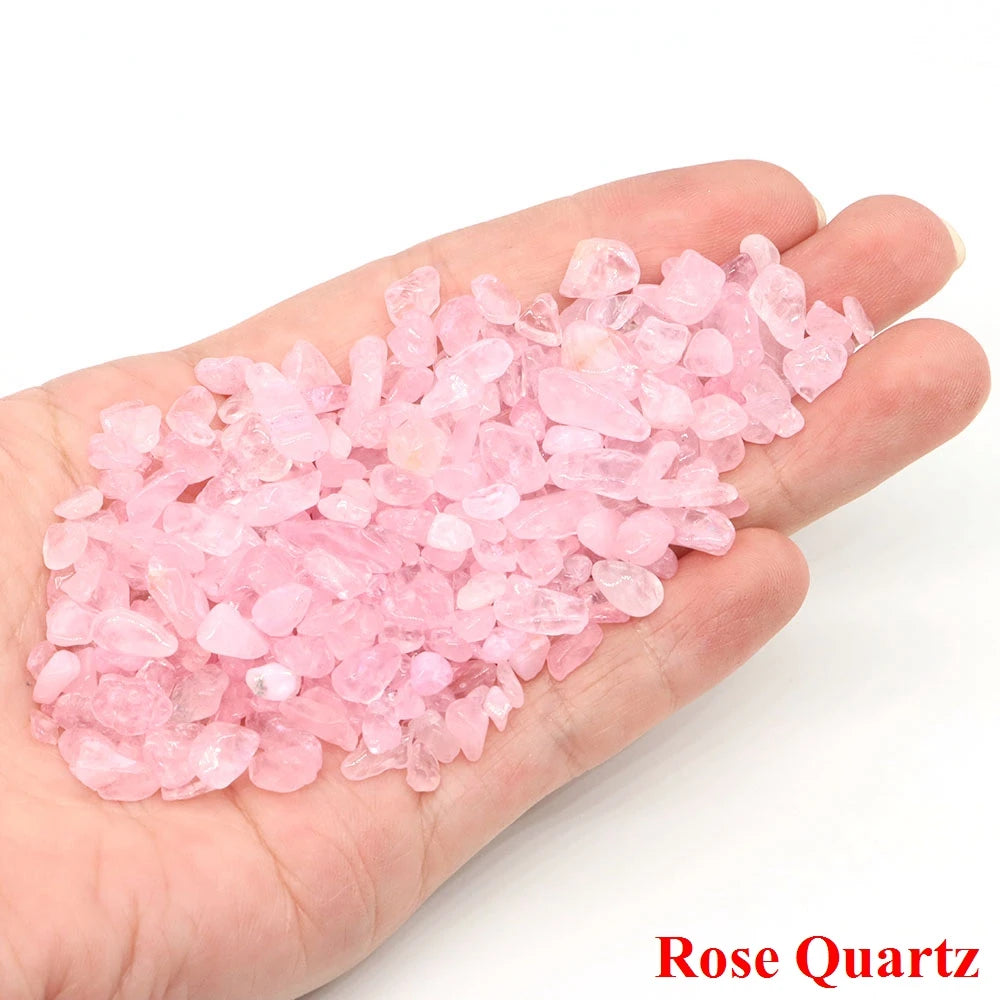 Hand holding pink rose quartz crystals on a white background