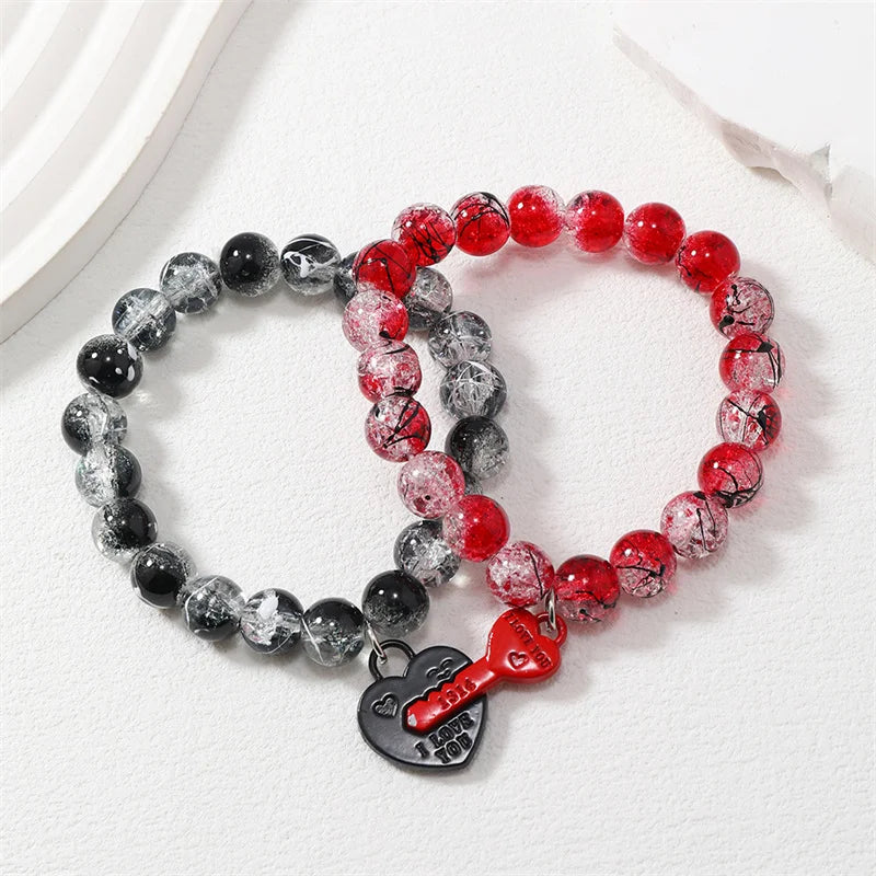 Three beaded bracelets with a heart-shaped key charm on a white background