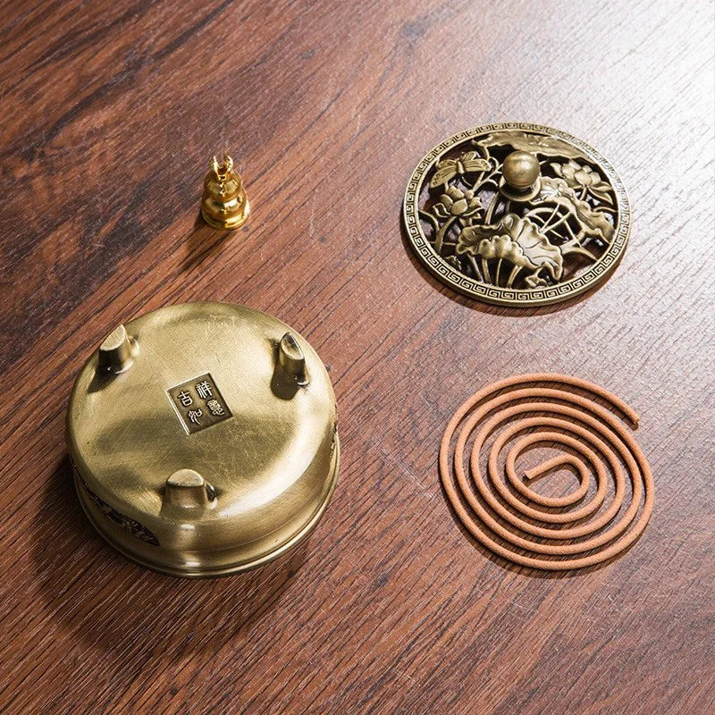 Brass incense burner, cone, and coil on a wooden surface