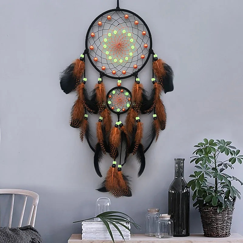 Dreamcatcher with feathers hanging on a gray wall with decor items below.