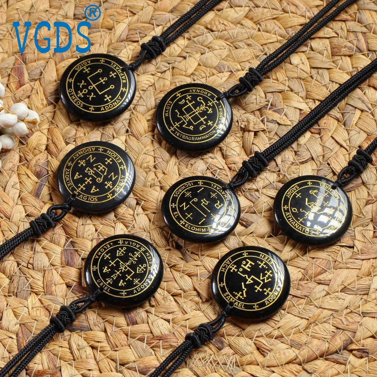 Black necklaces with circular pendant designs on a woven mat background