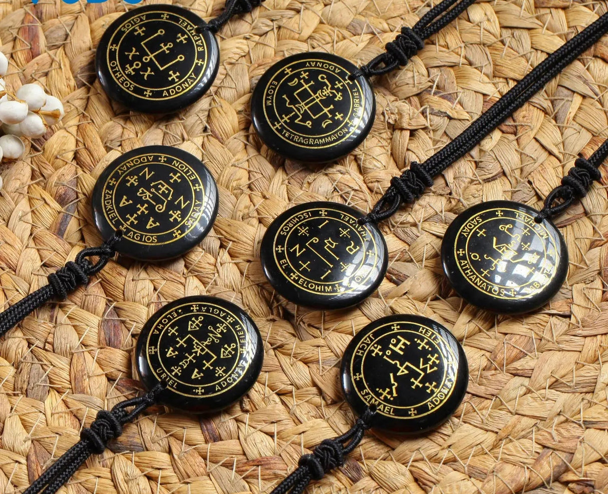 Black necklaces with circular pendant designs on a woven mat background