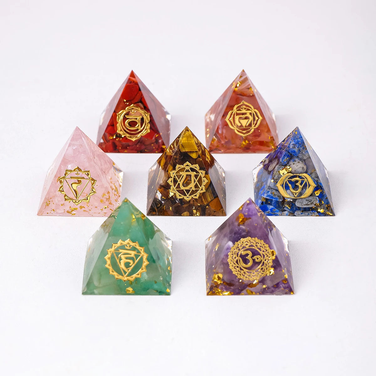 Set of colorful crystal pyramids with gold symbols on a white background