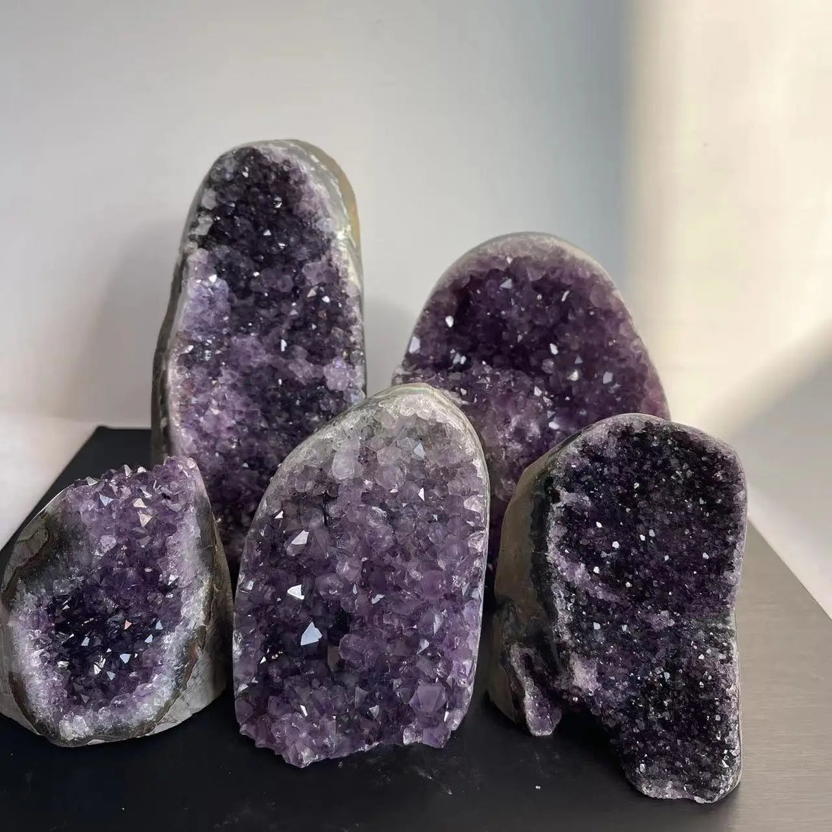 Amethyst geode crystals on a dark surface with a blurred background