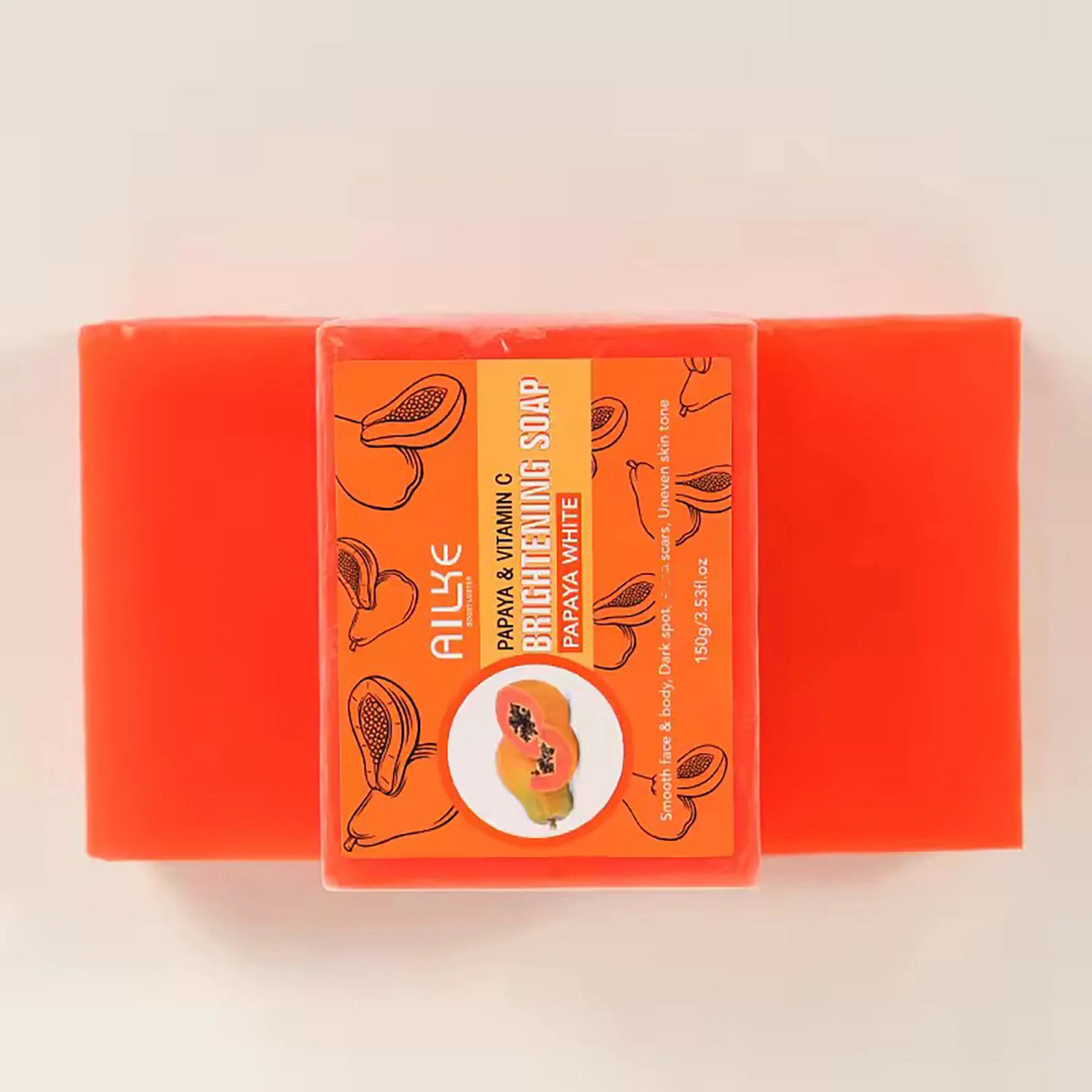 Two bars of red soap with an orange label featuring a papaya illustration on a light pink background.