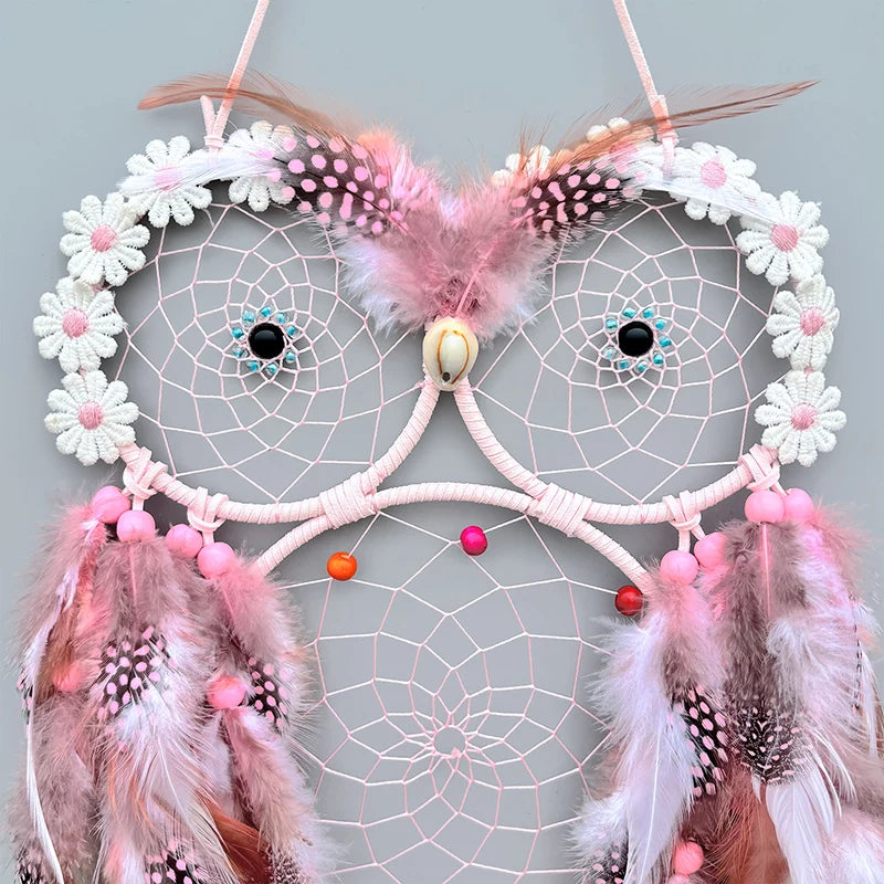 Pink and white dreamcatcher with feathers on a light gray background