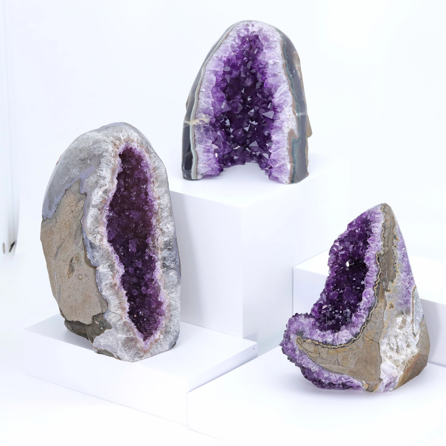Three amethyst geodes on a white background