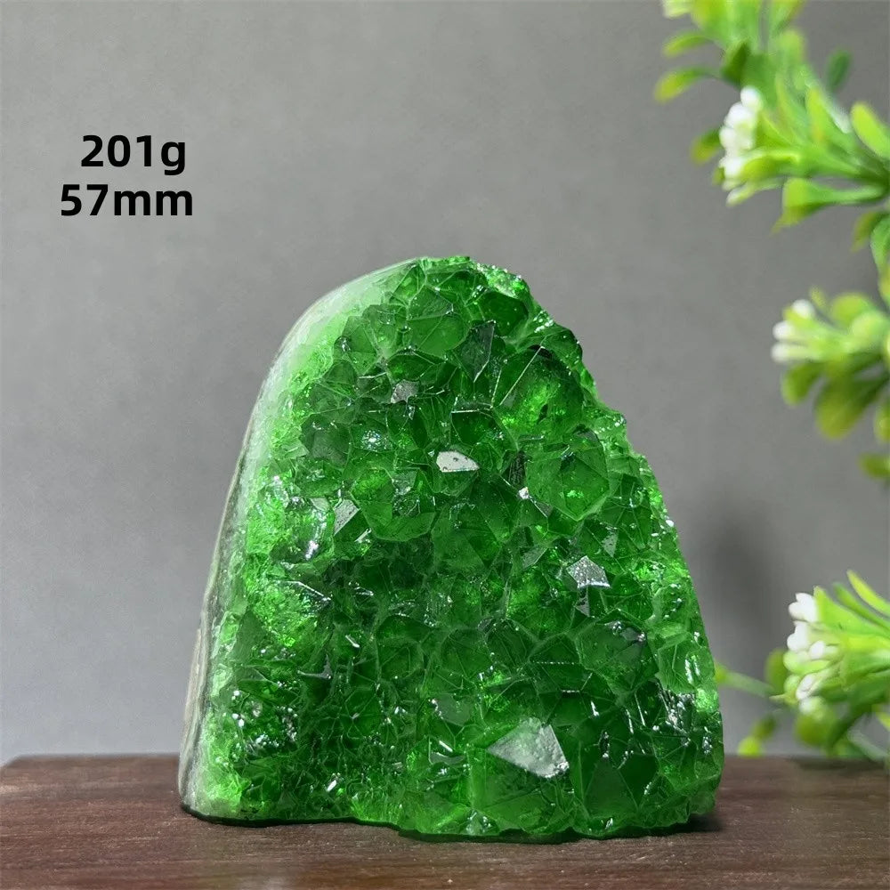 Green crystal rock on a wooden surface with a gray background