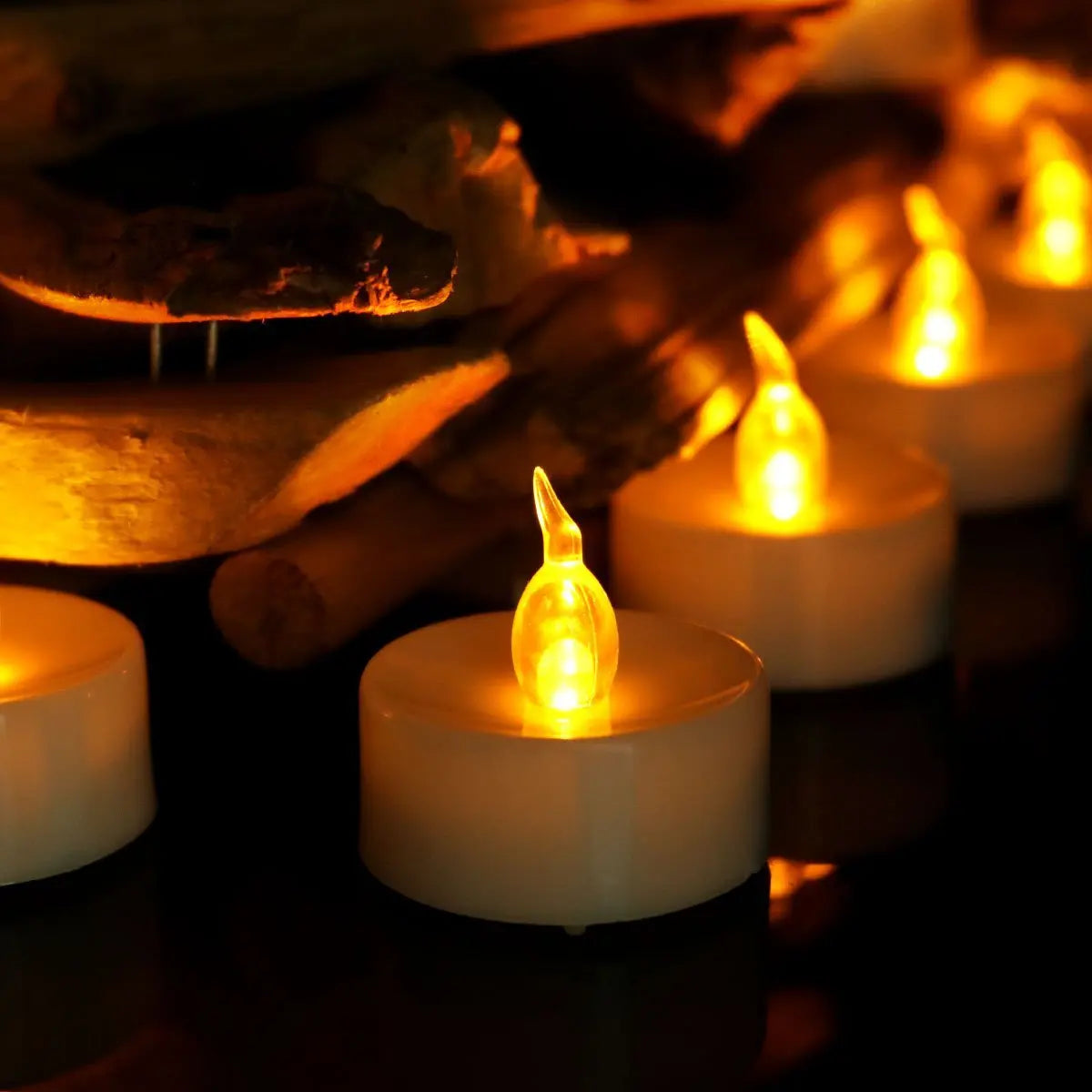 Flickering tealight candles on a dark background