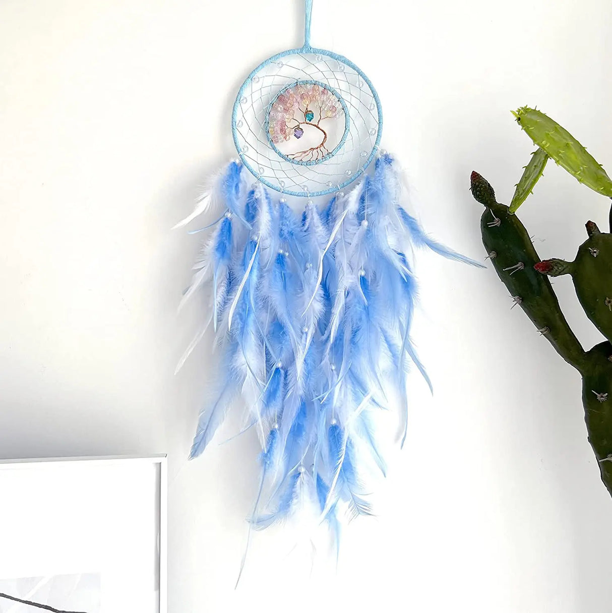 Blue dreamcatcher with feathers on a white background