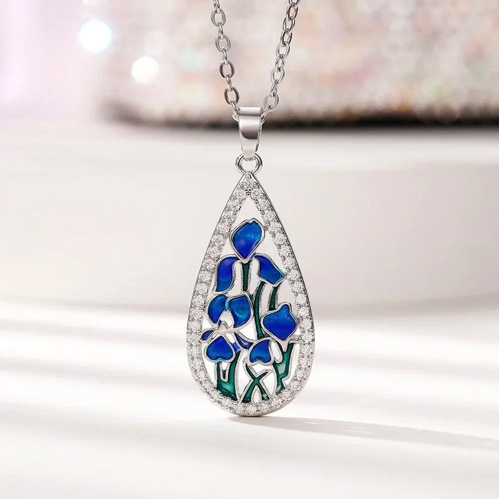 Teardrop-shaped pendant with blue floral design on a white background