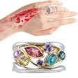 Multicolored gemstone ring on a hand with a close-up of skin texture.