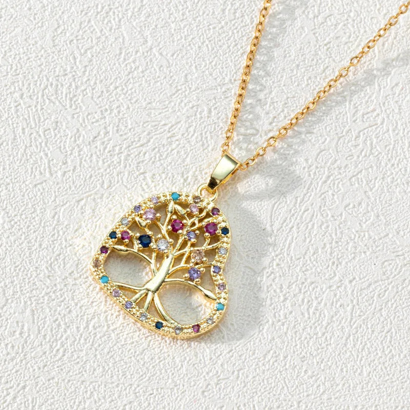 Gold necklace with a tree-shaped pendant featuring colorful gemstones on a light gray background