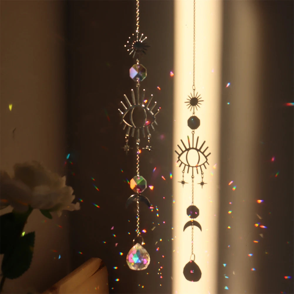 Decorative hanging crystal with eye and moon designs in front of a light source.