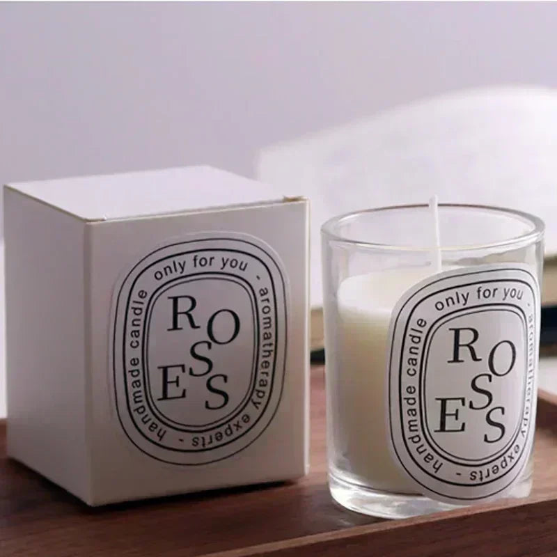 Candle with 'ROSES' label and packaging on a wooden surface