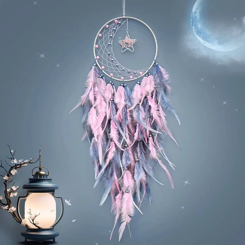 Decorative dreamcatcher with pink and blue feathers against a starry night sky.