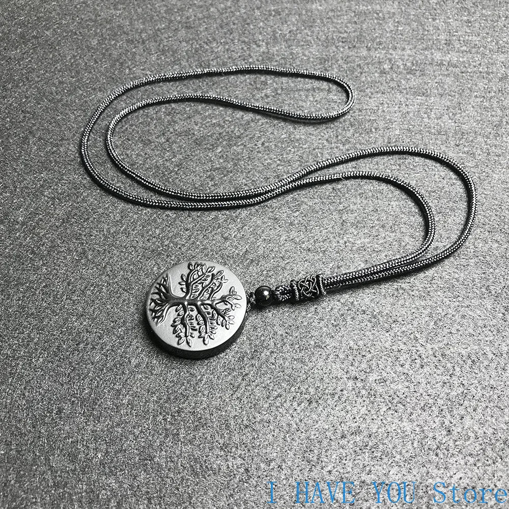 Silver necklace with a round pendant on a gray surface