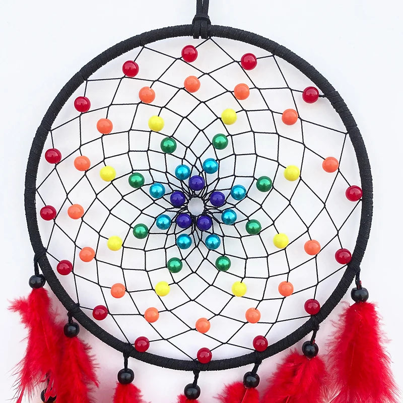 Dreamcatcher with colorful beads and red feathers on a white background