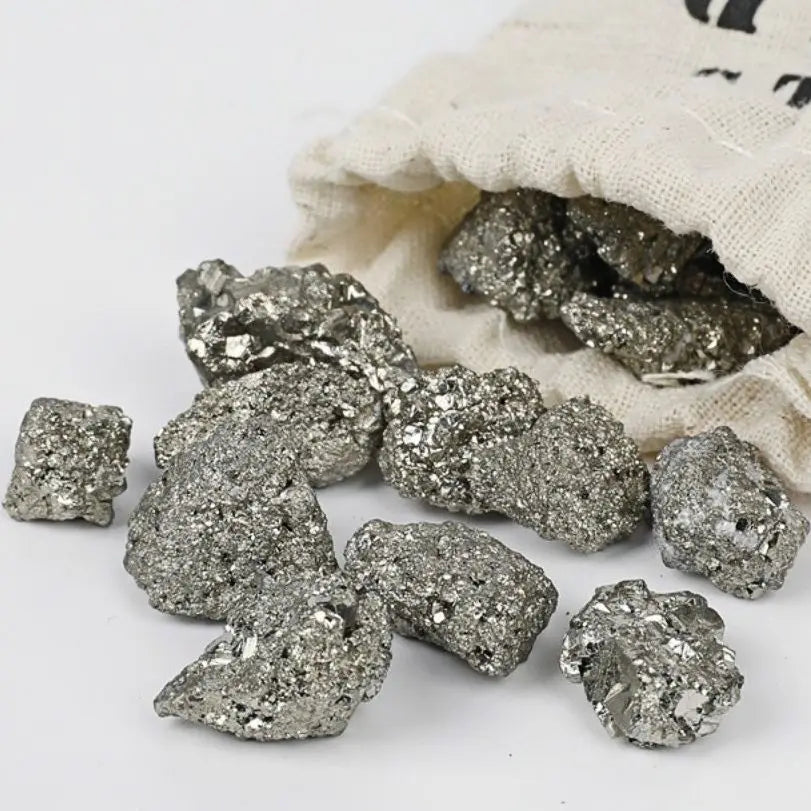 Raw pyrite crystals with a cloth bag on a white background