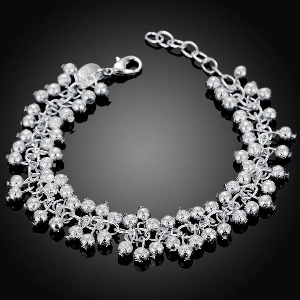Silver beaded bracelet on a black background