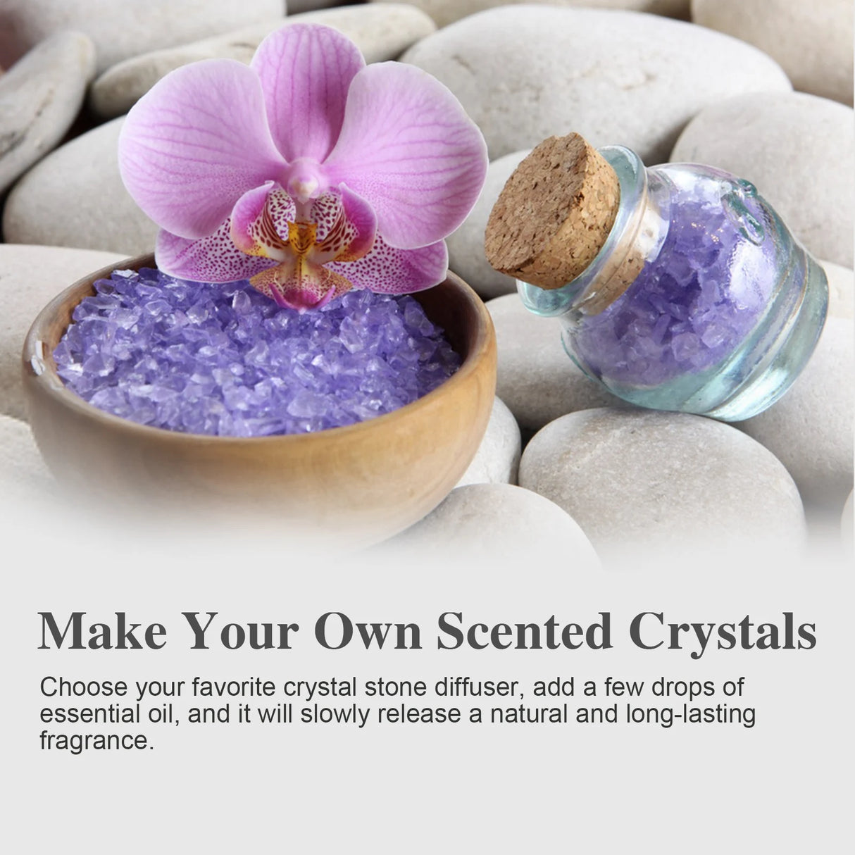 Pink orchid in a bowl of purple crystals with a bottle of essential oil on stones, promoting making scented crystals.