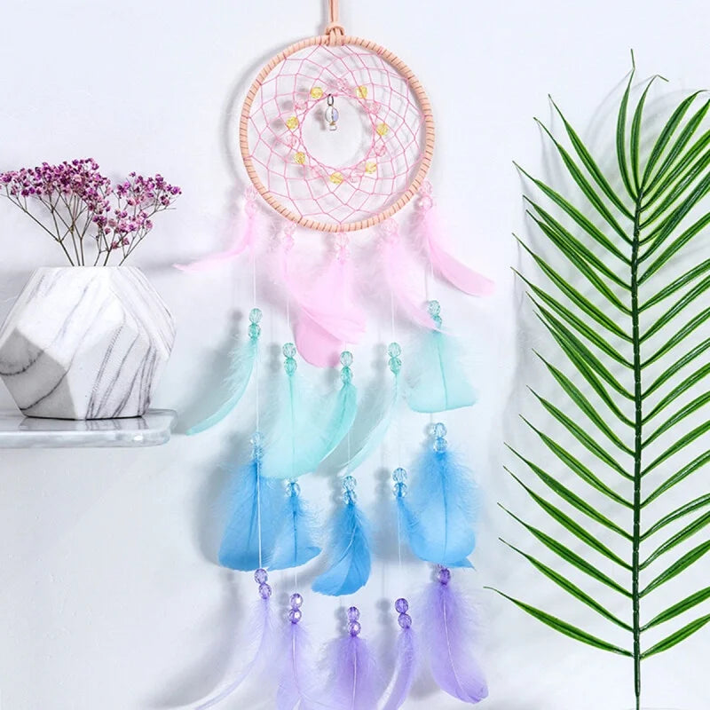 Colorful dreamcatcher with feathers against a light background